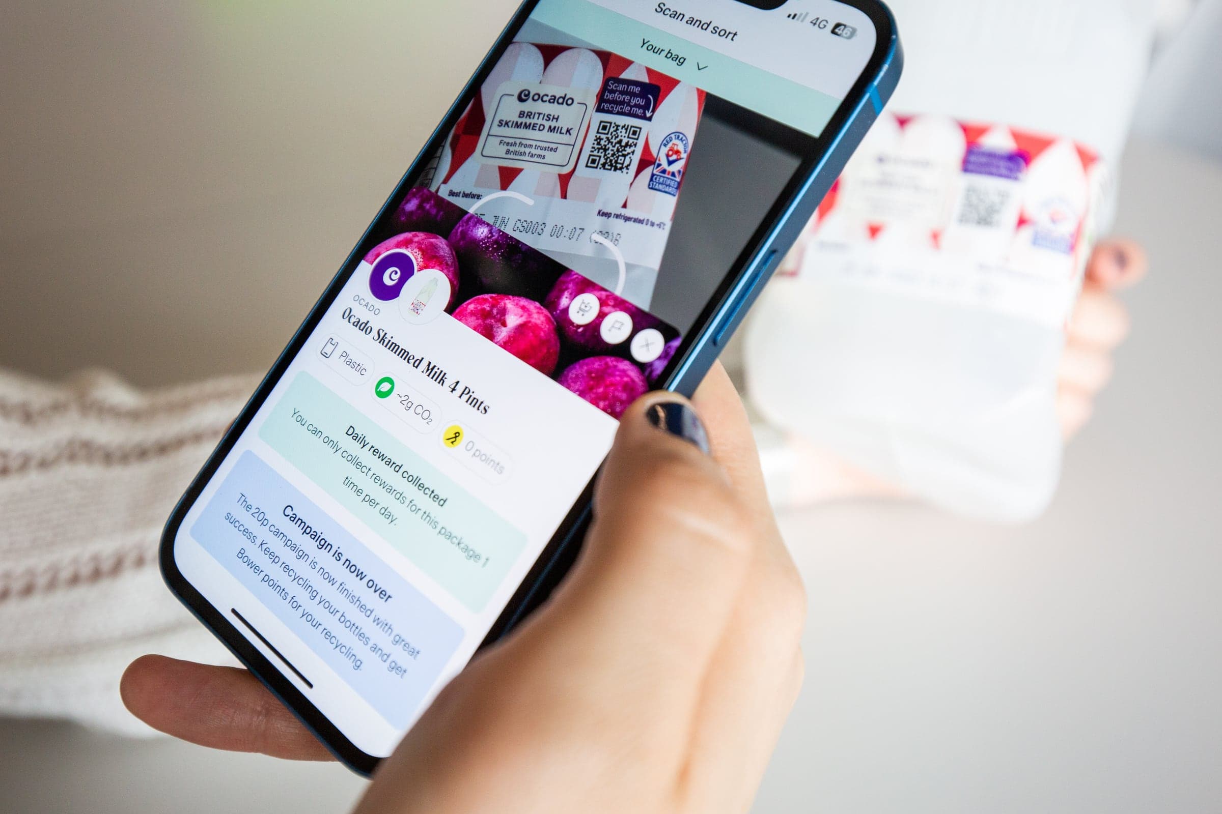 A shopper scanning the Smart QR Code on an Ocado British skimmed milk bottle, with the Bower app showing the pack, its recycling reward and the end of the 20p campaign