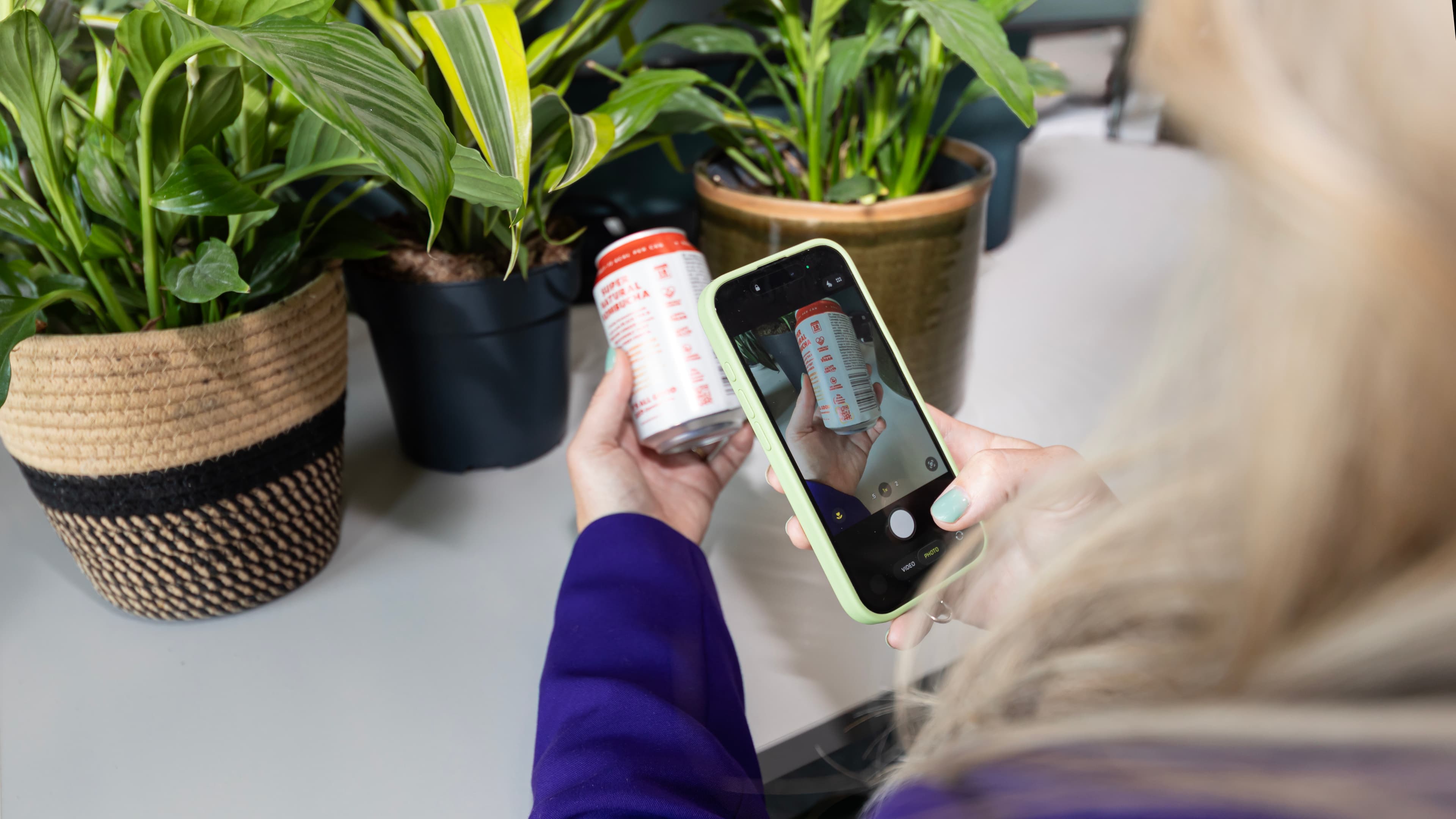 A phone scanning the QR code on a sports drink bottle