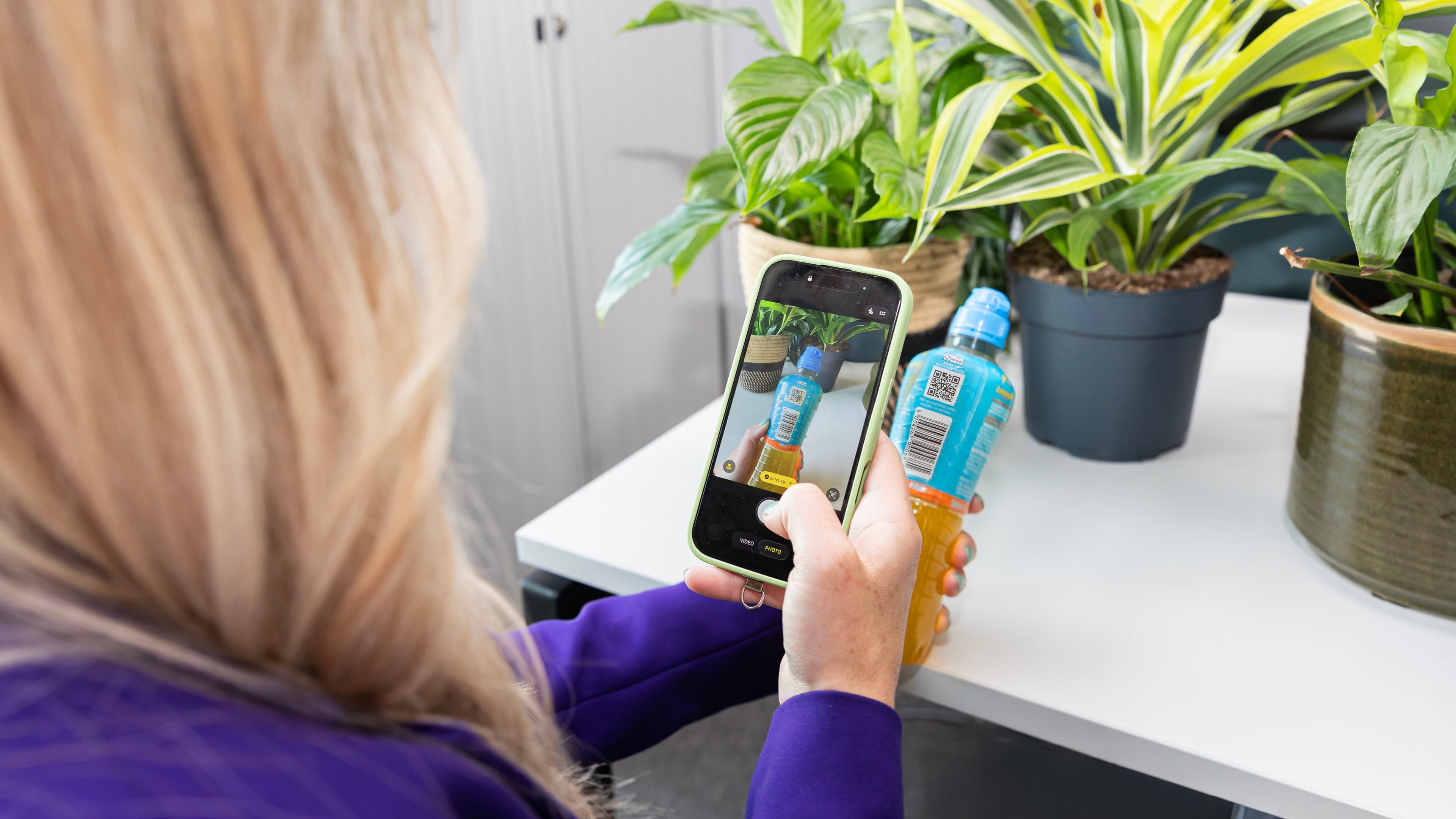 Un móvil que escanea el Smart QR Code de una botella de bebida