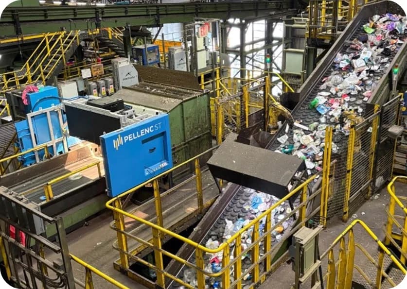 Una unidad de clasificación de Pellenc ST situada sobre una cinta transportadora de envases mezclados en un centro de reciclaje