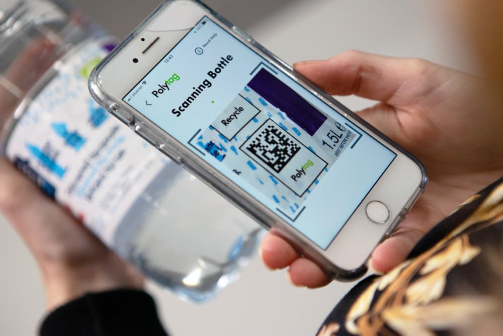 Photo showing a smartphone scanning a QR code on a bottle