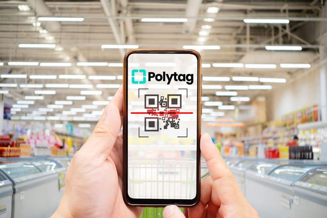 Photo of smartphone displaying a QR code with a supermarket in the background.