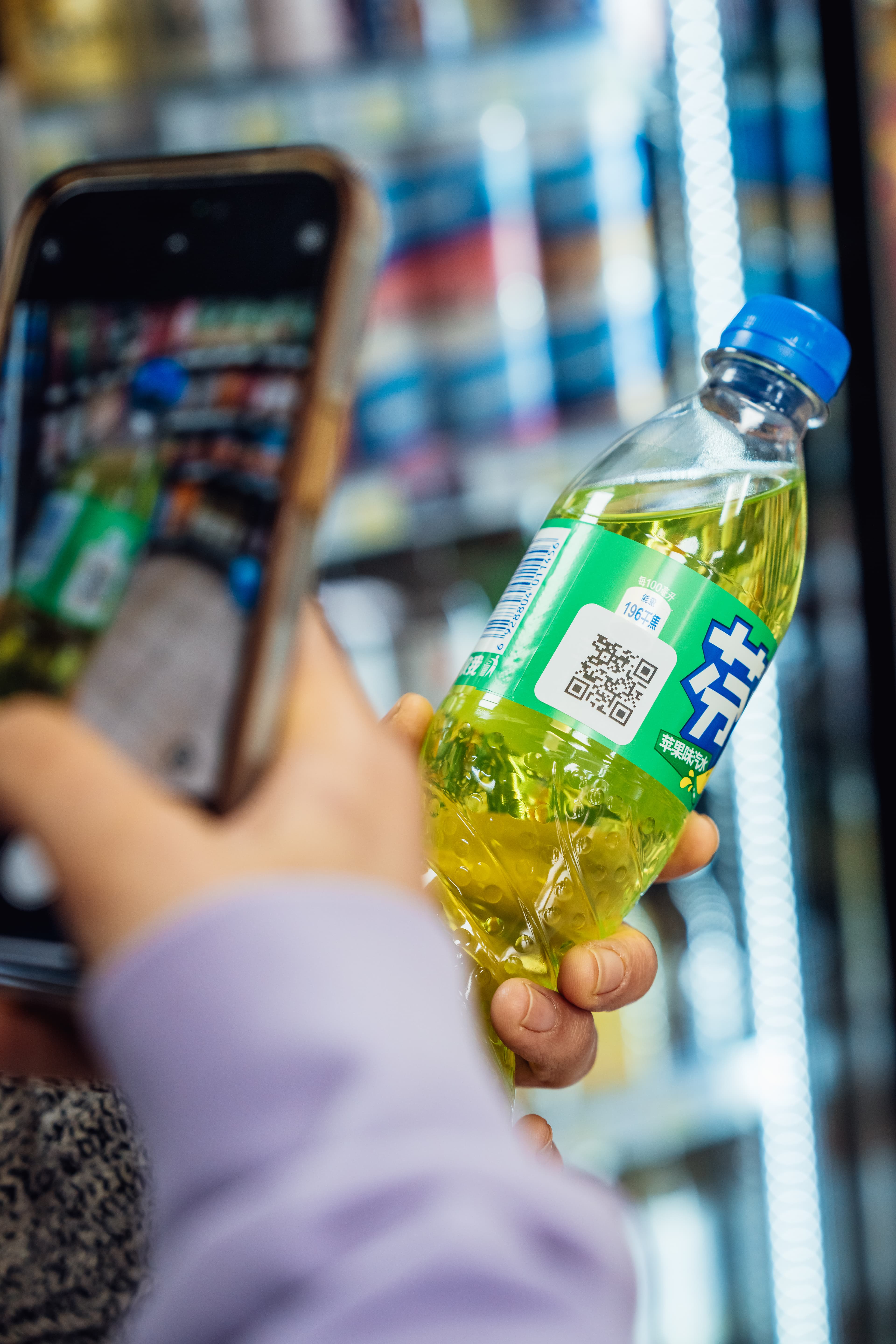 A phone camera scanning the QR code on a water bottle